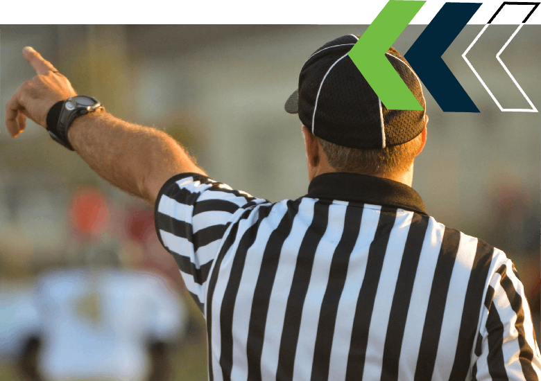about h2 A referee pointing to the right while holding his arm out.